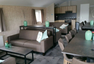Binnenruimte van Group lodge op Holiday park Eigen Wijze, Nederland, met zitbanken en grote tafels.