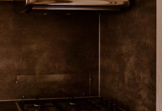 Cocina moderna con estufa de gas y campana en Group Lodge del parque Holiday Eigen Wijze, Países Bajos.