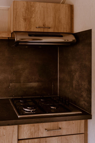 Moderne Gasherd und Dunstabzugshaube in einer Küchenzeile der Group Lodge im Holiday Park Eigen Wijze.