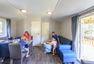 Familia disfrutando junta en una cabaña moderna en Veluwecamping De Pampel, Países Bajos, con niños.