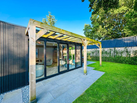 Outdoor view of the Eco Lodge at Uniq Leisure in the Netherlands with modern patio and green lawn.