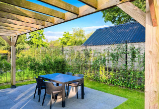 Udendørs terrasse med pergola og havemøbler på Eco Lodge ved Uniq Leisure, omgivet af grønt i Holland.