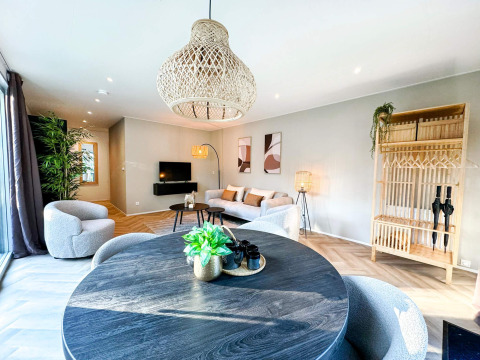 Amplia y moderna sala de Eco Lodge en Uniq Leisure, Países Bajos, con decoración elegante y luz natural.