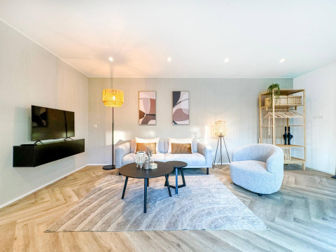 Luminoso salón moderno en Eco Lodge de Uniq Leisure, Países Bajos, con muebles cómodos y decoración elegante.