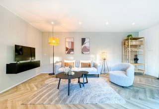 Stilfuldt moderne opholdsstue i Eco Lodge med lyse farver, komfortable møbler og elegant indretning.