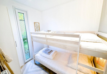 Habitación luminosa con litera y acceso al jardín en Eco Lodge de Uniq Leisure, Países Bajos.