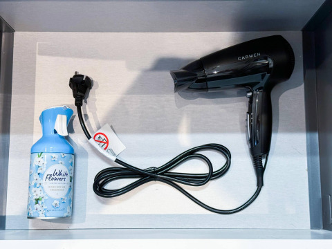 A hair dryer and an air freshener can placed side by side in a drawer at Eco Lodge at Uniq Leisure, Netherlands.