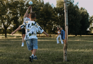 Kinderen voetballen samen op het gras bij Feather Down Landgoed ter Wijnendale, West-Vlaanderen.