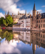 Belle vue sur un canal avec reflets de bâtiments historiques, idéale pour des vacances glamping en Europe.