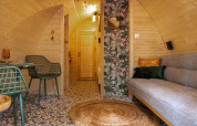 Cozy Boshuys tiny house interior at Buitengoed Ruysbos, Netherlands, with wooden walls and colorful decor.