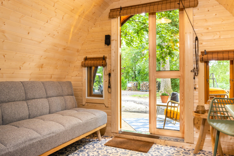 Interieur van de Boshuys tiny house bij Buitengoed Ruysbos, met houten wanden en uitzicht op natuur.