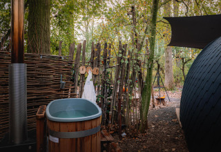 Außenbadewanne und Sauna neben einem kleinen Haus im Wald bei Boshuys, Buitengoed Ruysbos, Niederlande.
