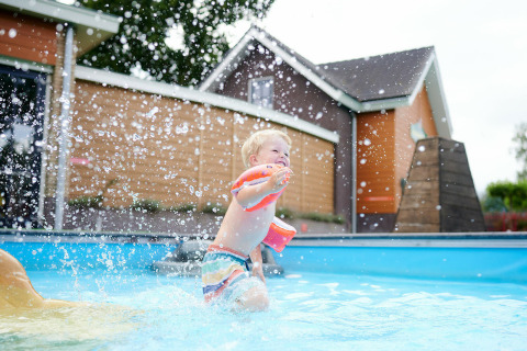 Niño pequeño chapoteando en la piscina con flotadores en Sand Lodge, Holiday Park De IJsvogel, Países Bajos.