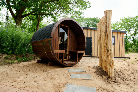 Sand Lodge Sauna bij Holiday Park De IJsvogel in Nederland, met barrelsauna en modern houten tiny house.