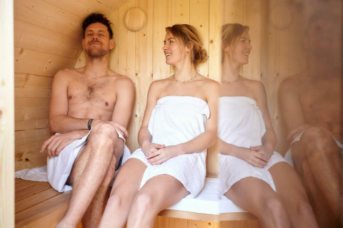 Een stel ontspant zich in de Sand Lodge Sauna bij Holiday Park De IJsvogel in Nederland.