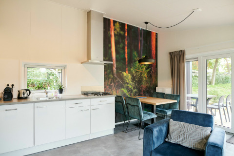 Modern tiny house kitchen and dining area with forest mural, trendy furniture, and garden view outside.