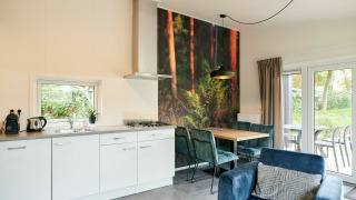 Cocina y comedor modernos en tiny house, decoración mural de bosque, muebles elegantes y vista al jardín.