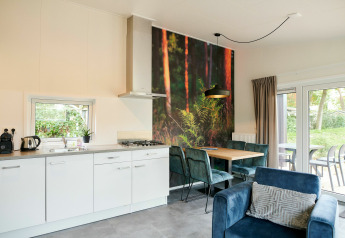 Cocina y comedor modernos en tiny house, decoración mural de bosque, muebles elegantes y vista al jardín.