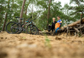 Deux personnes font une pause à vélo dans la forêt près du Sand Lodge Sauna, De IJsvogel, Pays-Bas.