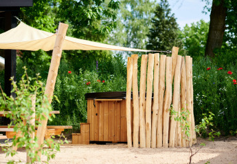 Jacuzzi extérieur avec écran en bois et voile d'ombrage à Sand Lodge au Holiday Park De IJsvogel, Pays-Bas.