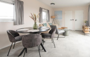 Moderne stue i Wood Lodge på Kompas Camping Nieuwpoort, Belgien, med spiseplads og stilfuld indretning.