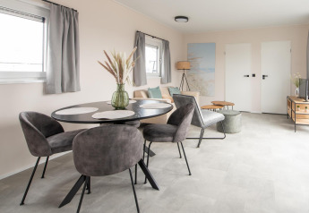 Moderne stue i Wood Lodge på Kompas Camping Nieuwpoort, Belgien, med spiseplads og stilfuld indretning.