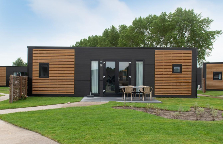 Moderne Holz-Lodge mit Terrasse und Sitzbereich bei Kompas Camping Nieuwpoort in Belgien, Hunde erlaubt.