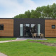 Moderne Holz-Lodge mit Terrasse und Sitzbereich bei Kompas Camping Nieuwpoort in Belgien, Hunde erlaubt.