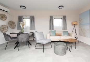Moderne stue i Wood Lodge på Kompas Camping Nieuwpoort, Belgien, med stilfuld indretning og gråt interiør.