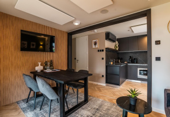 Salle à manger et séjour modernes à Enzian Hottub au lac Ossiacher en Autriche, avec une décoration stylée et cuisine.