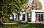 Villa Maritiem en MarinaPark Bad Nederrijn, Países Bajos, rodeada de árboles y arquitectura moderna.