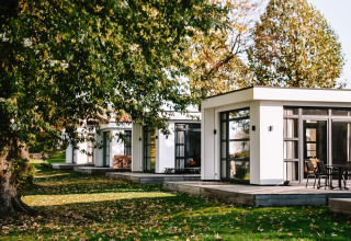 Villa Maritiem en MarinaPark Bad Nederrijn, Países Bajos, rodeada de árboles y arquitectura moderna.