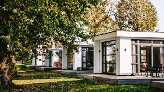 Villa Maritiem au MarinaPark Bad Nederrijn aux Pays-Bas, avec terrasse et arbres verdoyants autour.