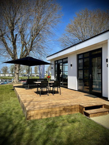 Zonnig terras bij Villa Maritiem in MarinaPark Bad Nederrijn, Nederland, met tuinset en parasol.