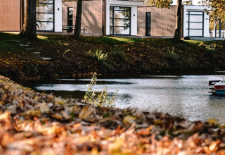 Lodge moderno junto al lago, Villa Maritiem en MarinaPark Bad Nederrijn, rodeado de árboles en Países Bajos.