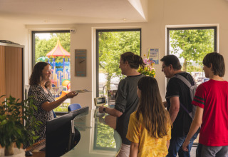 Una famiglia effettua il check-in alla Villa Maritiem, MarinaPark Bad Nederrijn, Paesi Bassi, parco giochi fuori.