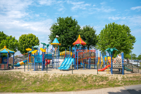Parque infantil colorido con toboganes y estructuras para escalar en Villa Maritiem, MarinaPark Bad Nederrijn, Países Bajos.