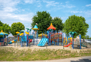 Farverig legeplads med rutsjebaner og klatrestativer ved Villa Maritiem, MarinaPark Bad Nederrijn, Nederlandene.
