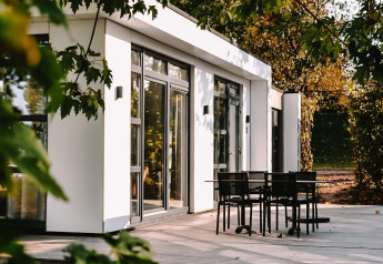 Modern Villa Maritiem lodge with spacious deck and outdoor dining at MarinaPark Bad Nederrijn, Netherlands.