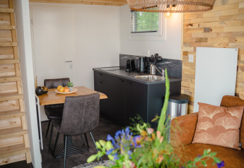 Modern tiny house kitchen and dining area at Tiny River House, MarinaPark Bad Nederrijn, Netherlands.