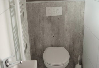 Baño pequeño y moderno con inodoro de pared y lavabo en Tiny River House, en los Países Bajos.