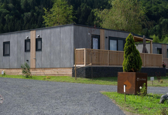 Lodge moderne au Wulfenia Waterfront au bord du lac Ossiacher See, Autriche, entouré de nature verdoyante.
