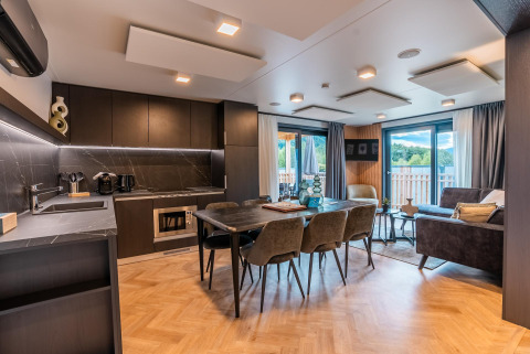 Moderna cabaña Wulfenia Waterfront en Ossiacher See, Austria, con cocina abierta, comedor y sala de estar.