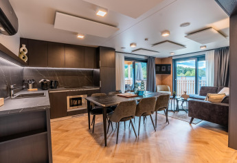 Moderne Wulfenia Waterfront lodge aan de Ossiacher See in Oostenrijk met open keuken, eet- en woonkamer.