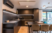 Moderne keuken en eetplek in Wulfenia Waterfront lodge bij Ossiacher See, Oostenrijk, met donker marmerdesign.