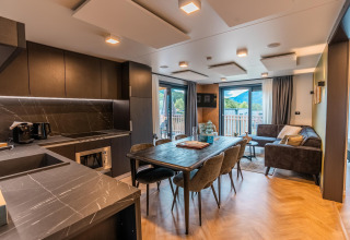 Cocina y sala modernas de planta abierta en Wulfenia Waterfront, Ossiacher See, con vistas a las montañas.