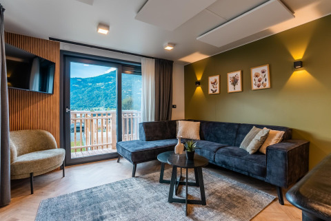 Salon moderne au Wulfenia Waterfront, Ossiacher See, Autriche, avec vue sur les montagnes et balcon.
