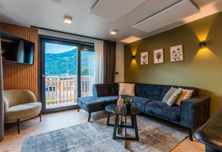 Salon moderne au Wulfenia Waterfront, Ossiacher See, Autriche, avec vue sur les montagnes et balcon.