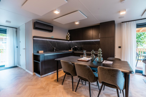 Cocina y comedor modernos en Wulfenia Waterfront Lodge junto al lago Ossiacher See, Austria, con decoración elegante.