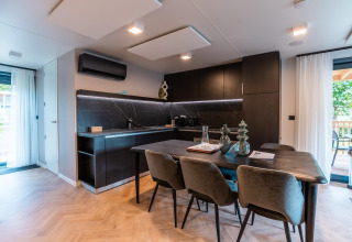 Cocina y comedor modernos en Wulfenia Waterfront Lodge junto al lago Ossiacher See, Austria, con decoración elegante.